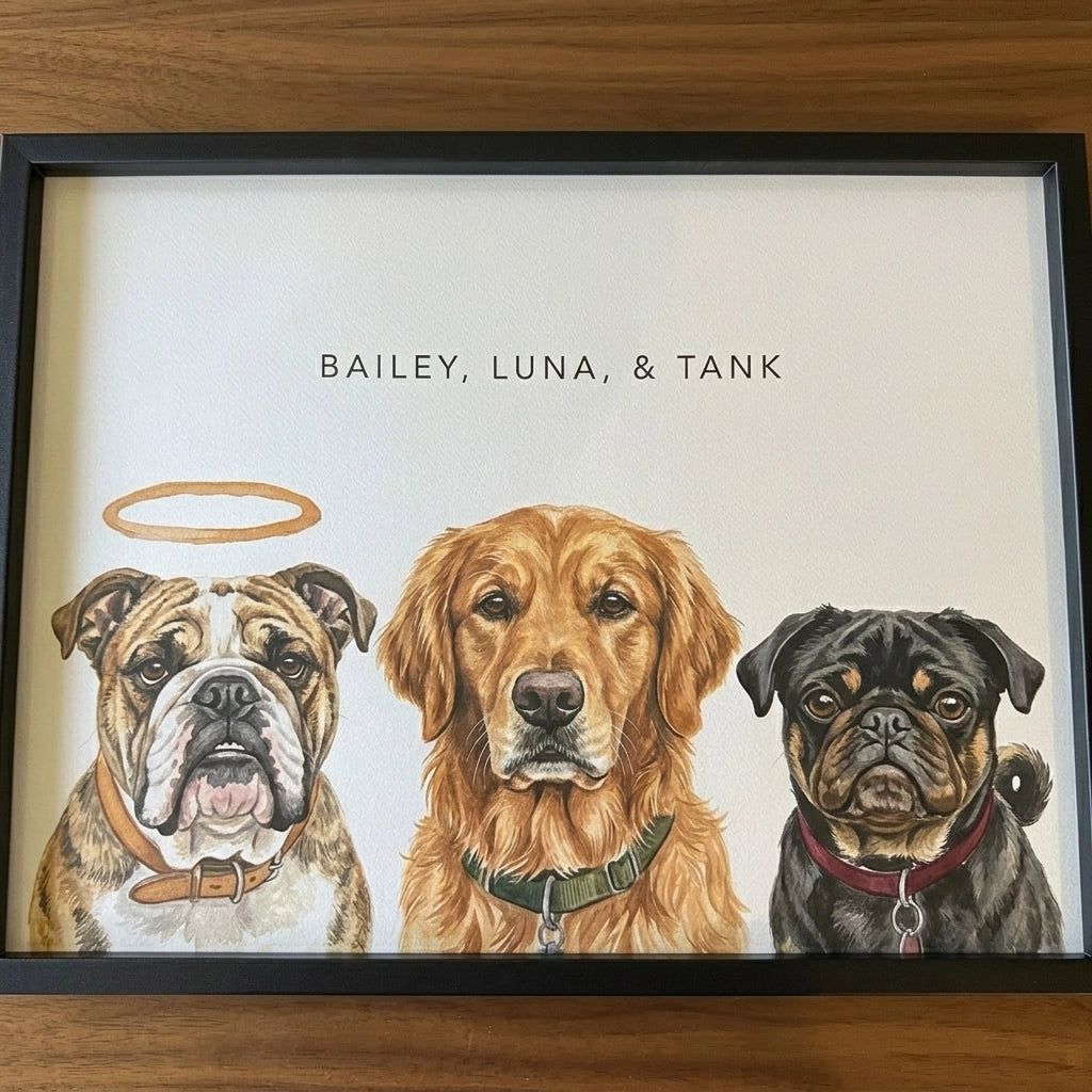 A framed custom pet memorial art print featuring three illustrated dogs: an bulldog with a gold halo on the left, a golden retriever in the center, and a black pug on the right. The text 'BAILEY, LUNA, & TANK' is printed at the top, and the artwork is displayed on a wooden surface.