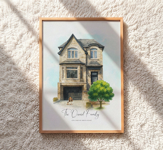 A framed custom watercolor art print of a two-story house with the text 'The Ouelal Family' and '104 CARTIER PRIVATE ROAD' at the bottom, displayed on a textured cream shag rug with soft shadows.
